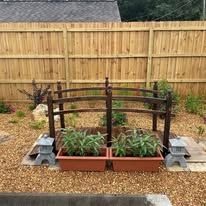 There is a wooden bridge in the middle of the garden.