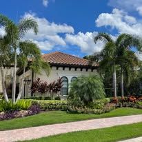 A large house with a lot of palm trees in front of it.