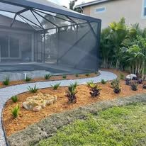 A backyard with a screened in pool and a walkway leading to it.