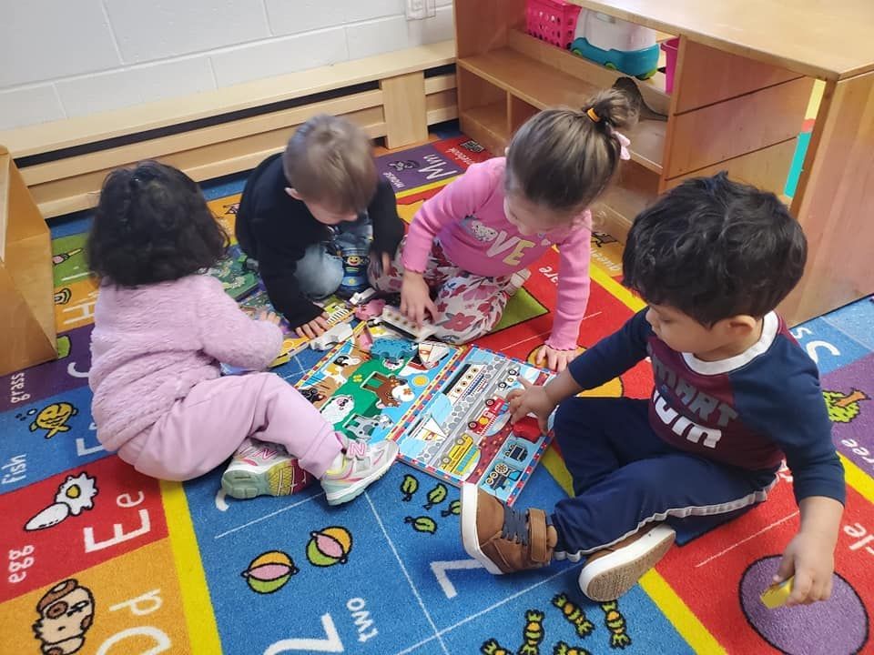 A group of children are sitting on the floor reading books.
