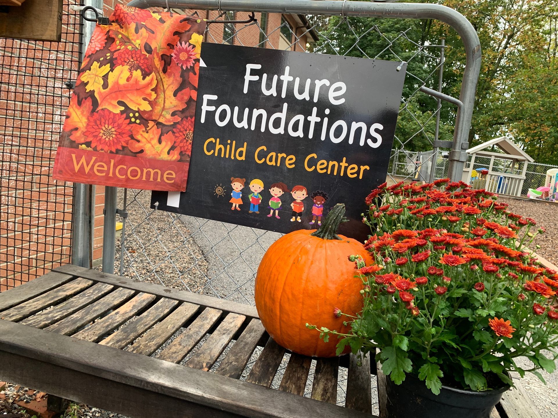 A pumpkin is sitting on a bench next to a sign for the future foundations child care center.