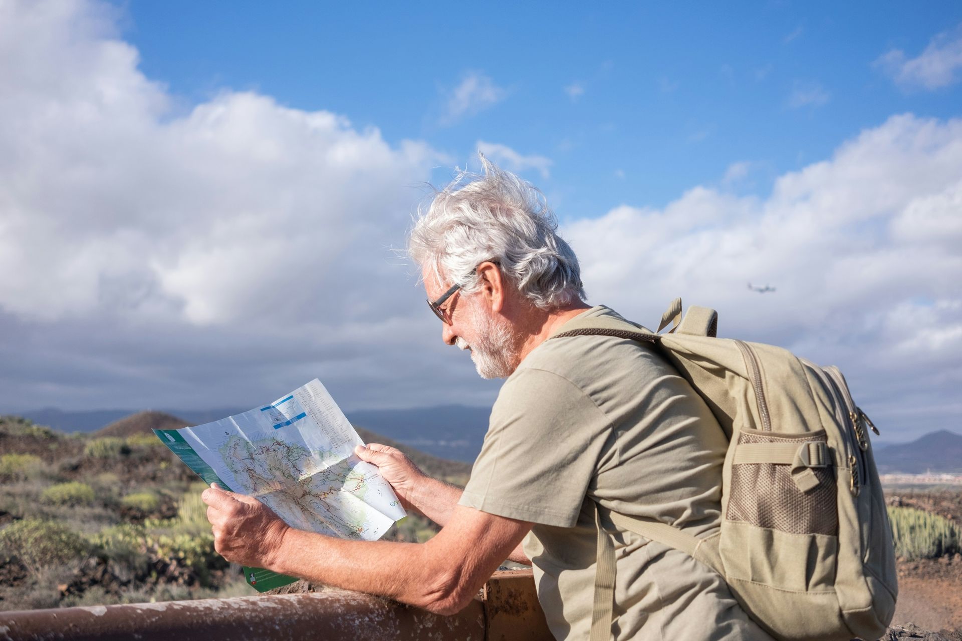 A man with a backpack is looking at a map.