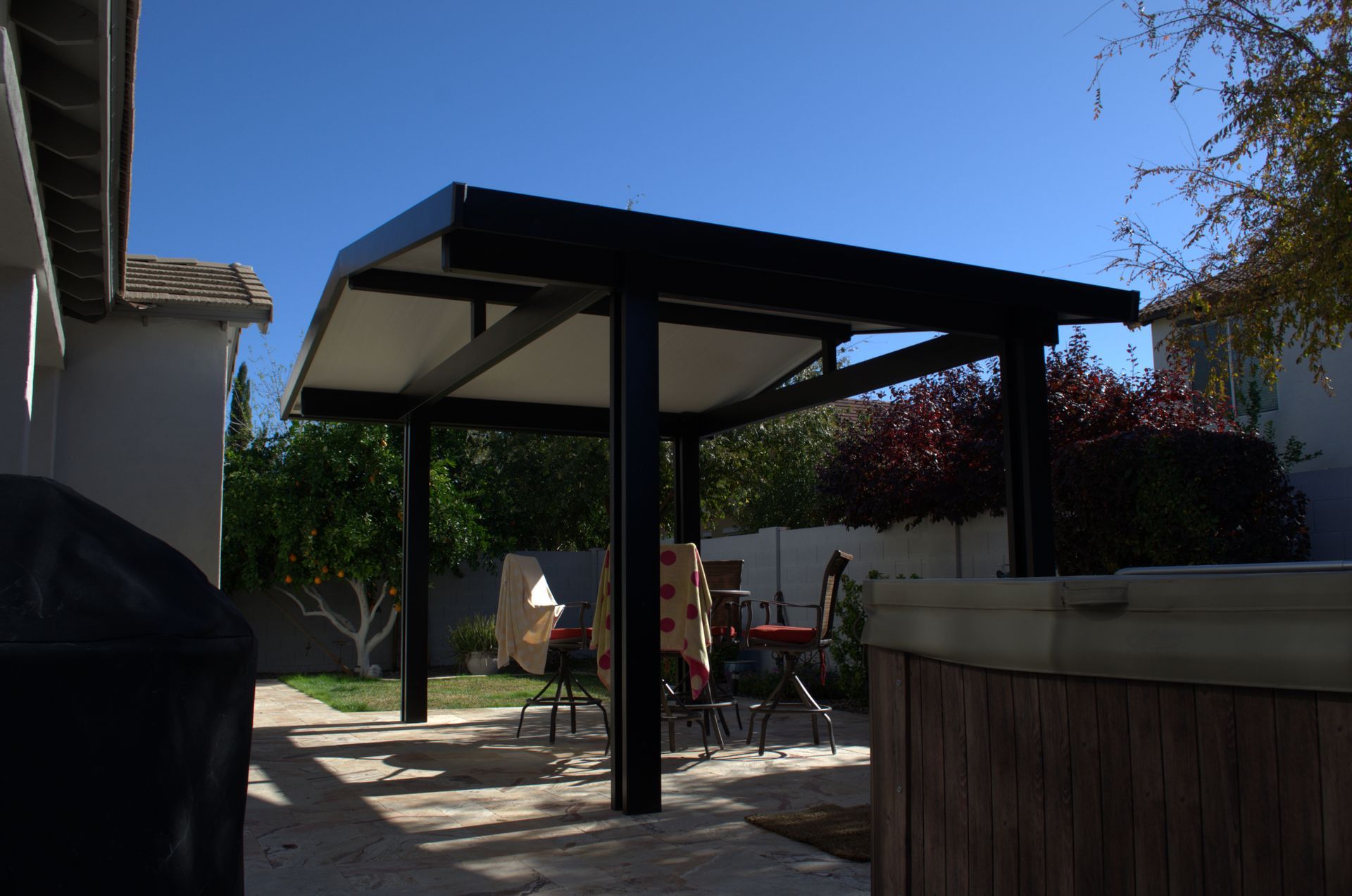 Aluminum pergola casting dappled light on a Tonopah home's terrace.