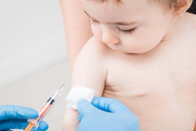 medico che inietta vaccino a bambino