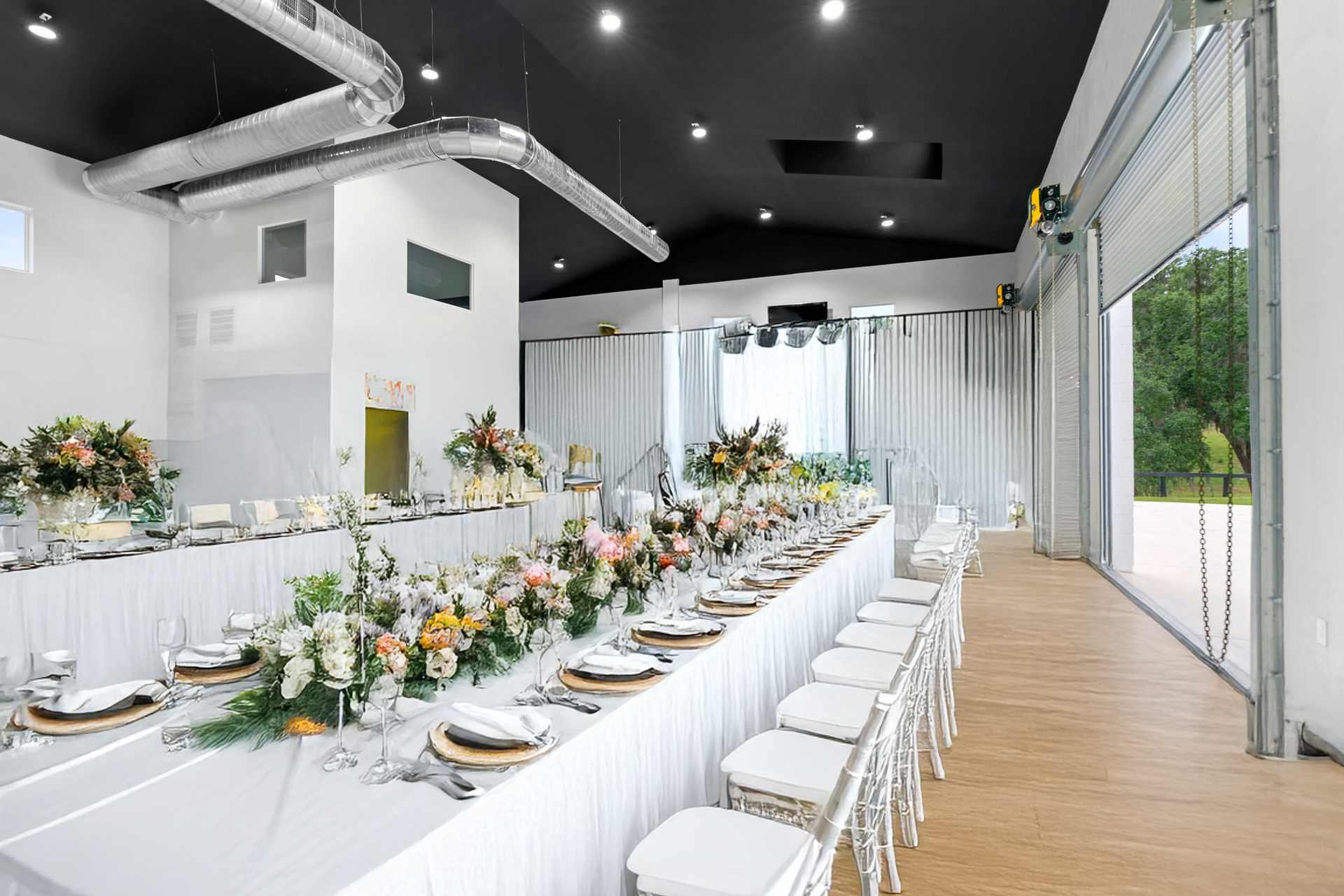 There is a long table with flowers on it in the middle of the room.