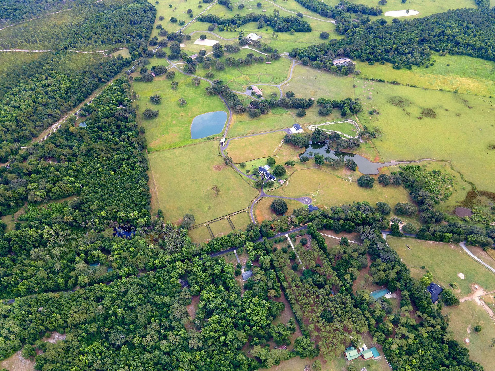 An aerial view of a lush green field surrounded by trees.