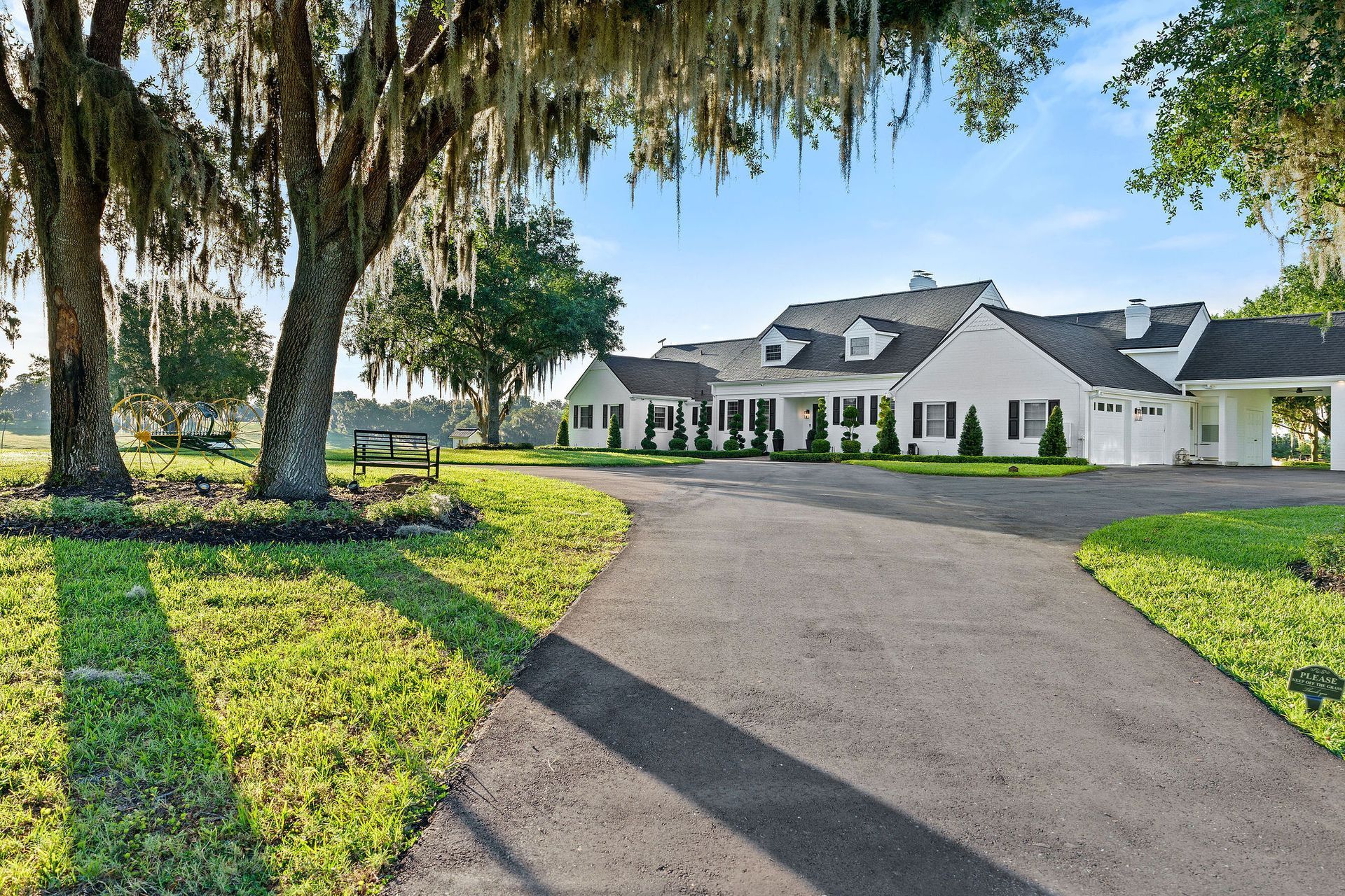 A large white house with a driveway leading to it