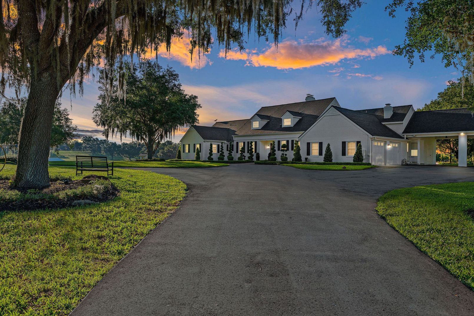 A large white house with a driveway leading to it