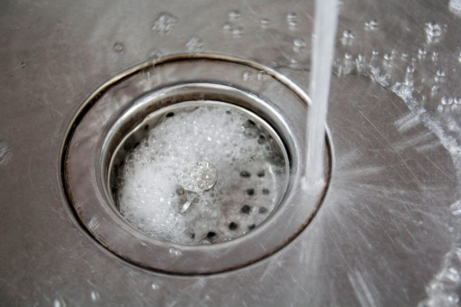 Water flowing into a stainless steel sink drain