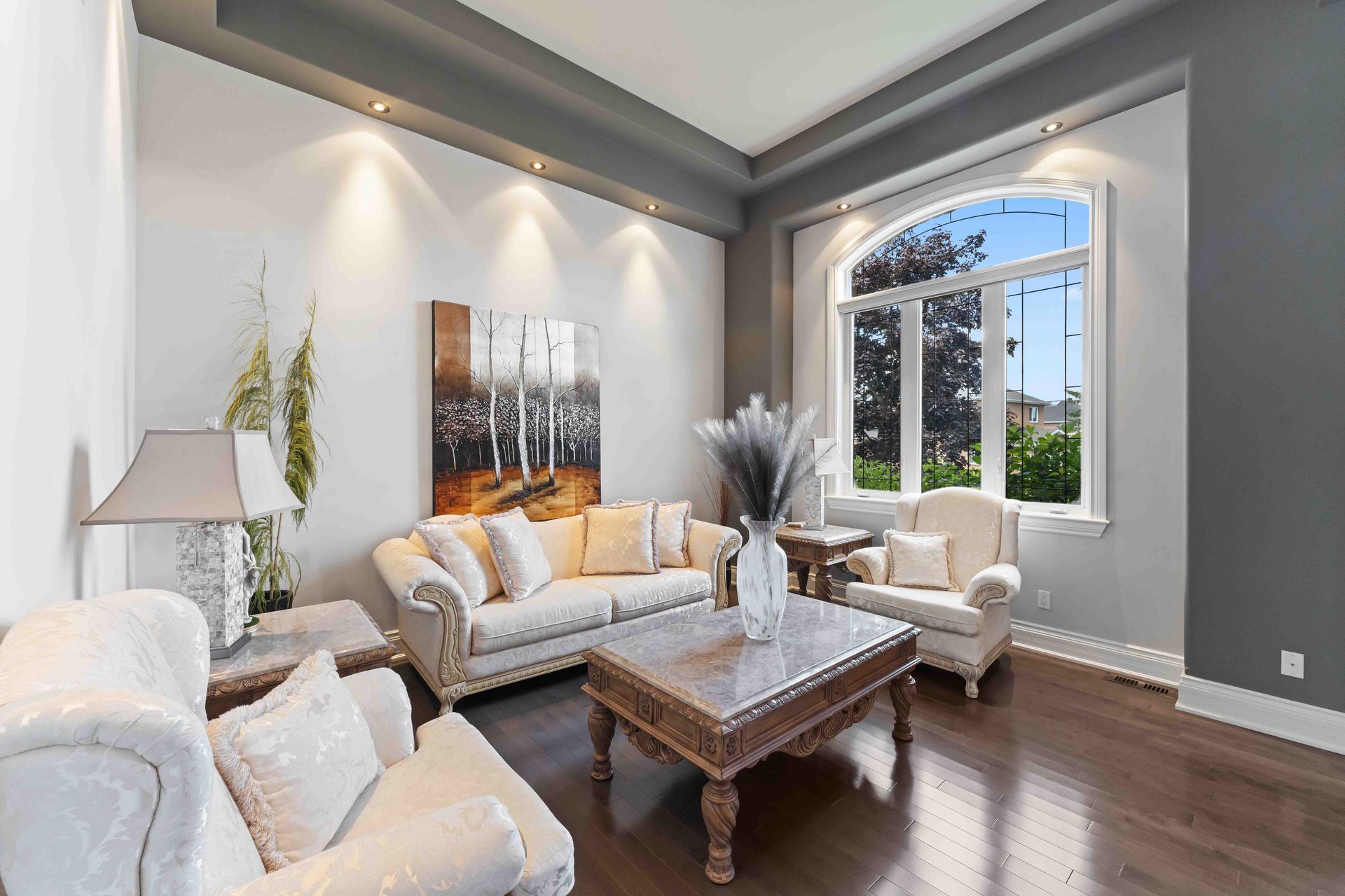 A living room with a couch , chairs , and a coffee table.