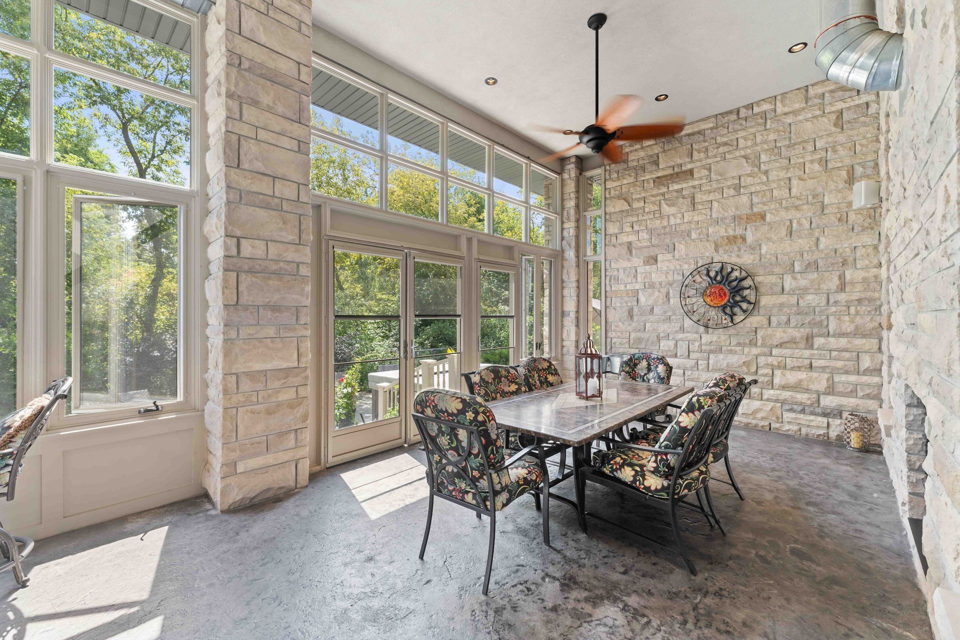 A large dining room with a table and chairs and a ceiling fan.