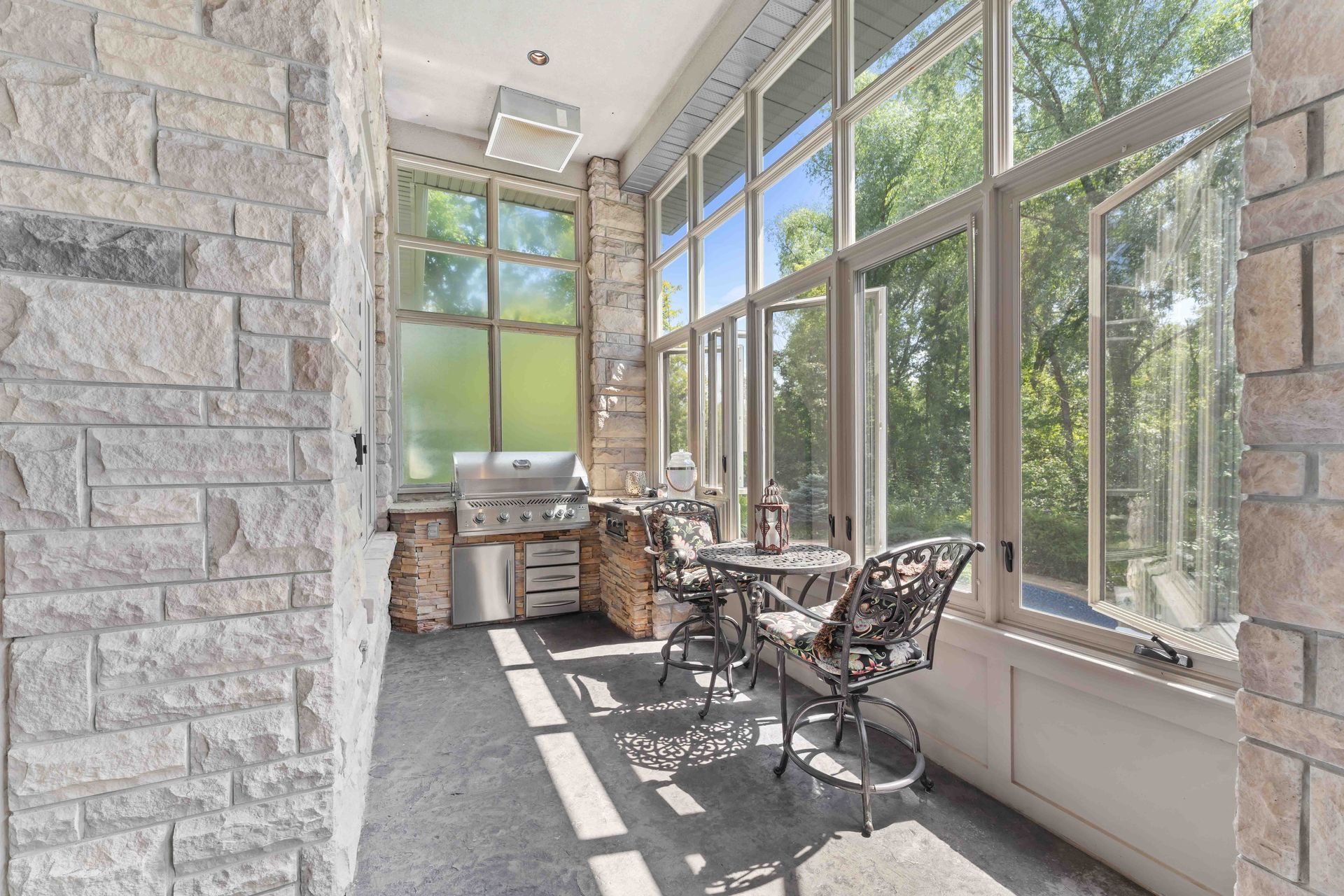 A sun room with a table and chairs and lots of windows.