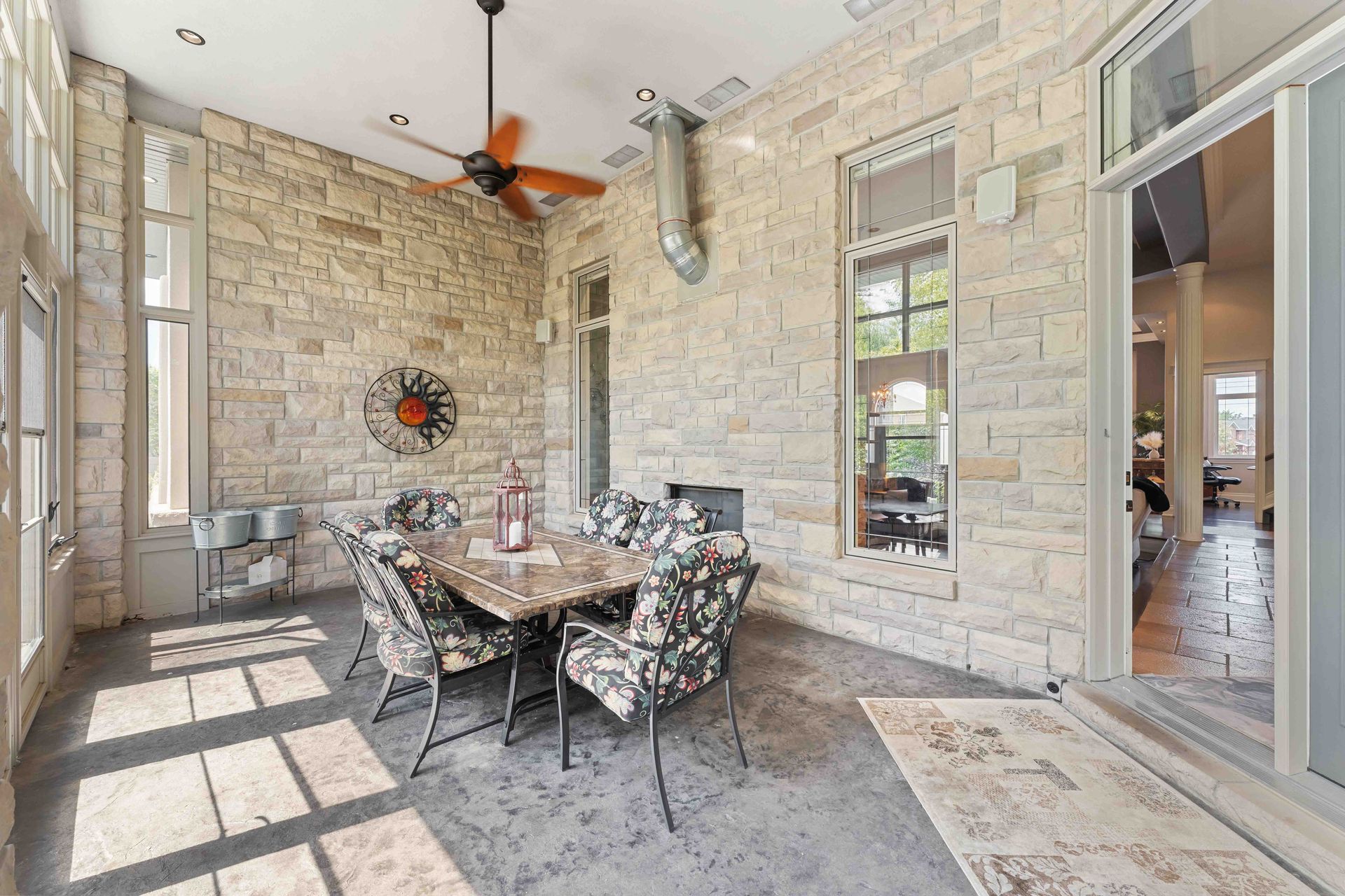 A dining room with a table and chairs and a ceiling fan.