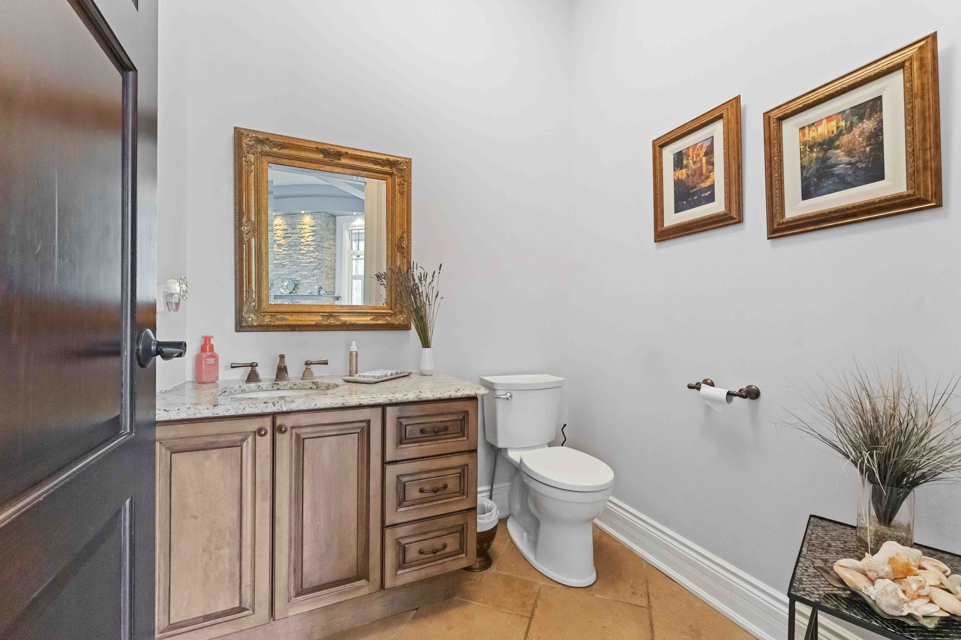A bathroom with a toilet , sink and mirror.