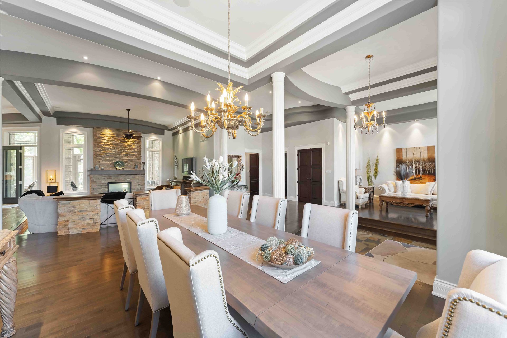 A large dining room with a long table and chairs and a chandelier.