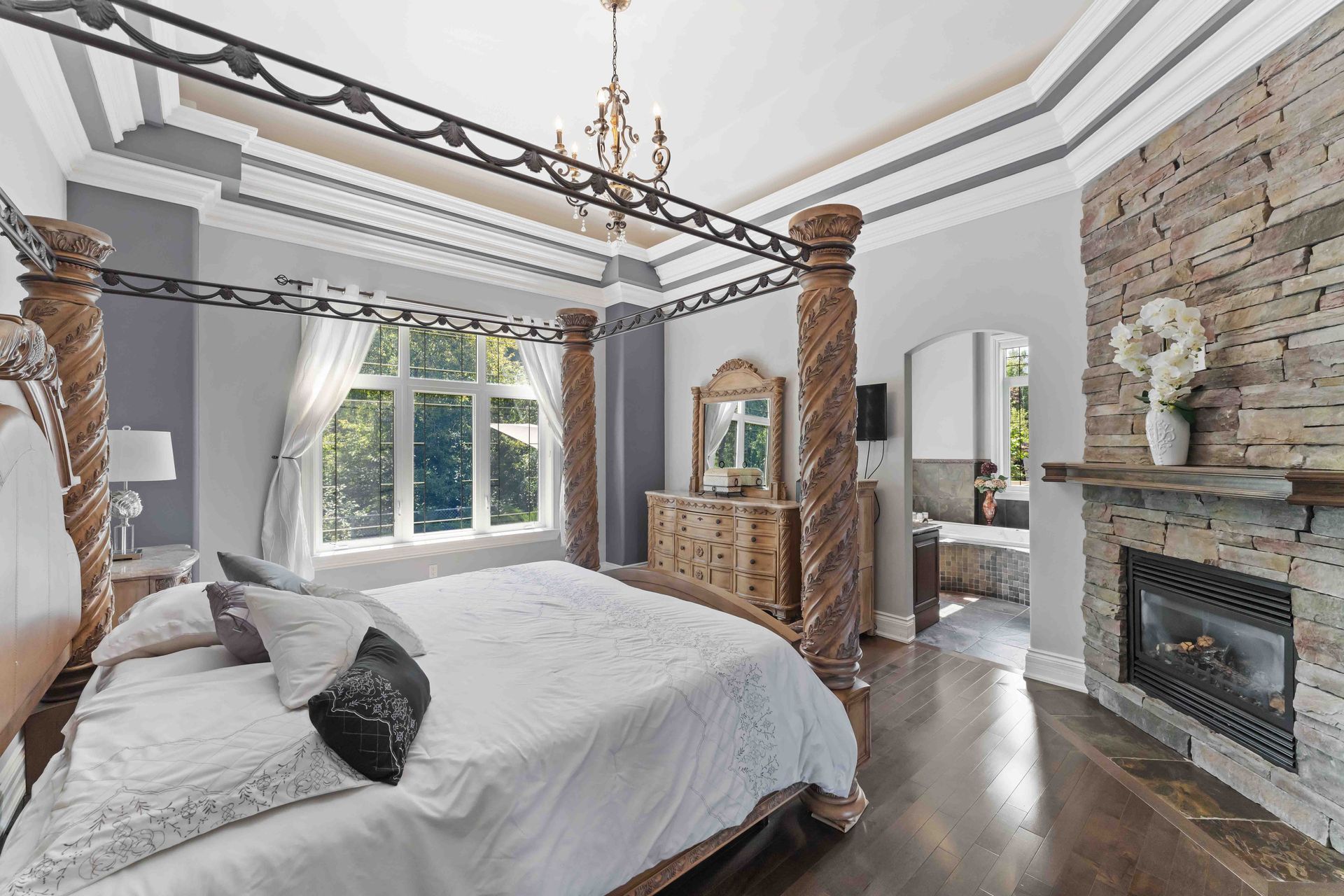 A bedroom with a canopy bed and a fireplace.