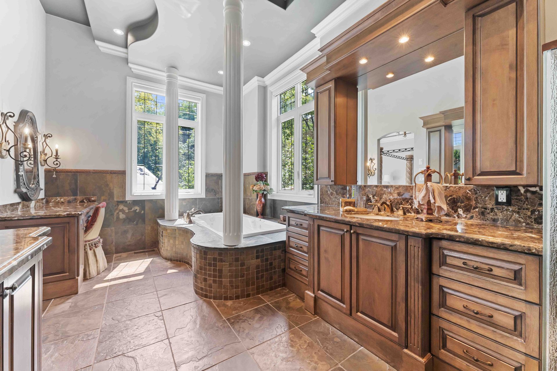 A bathroom with a tub , sinks , mirrors and cabinets.