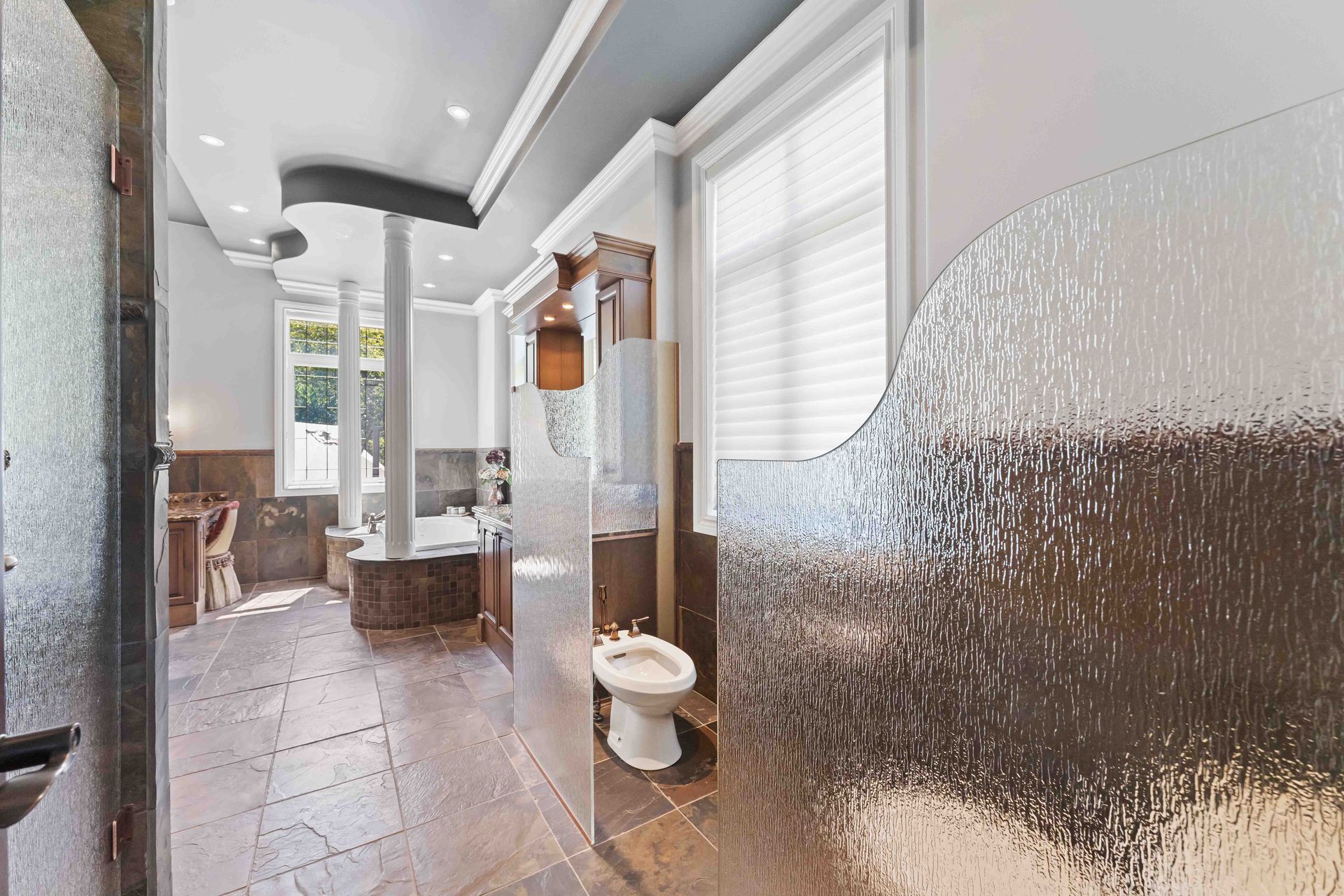 A bathroom with a toilet and a glass wall