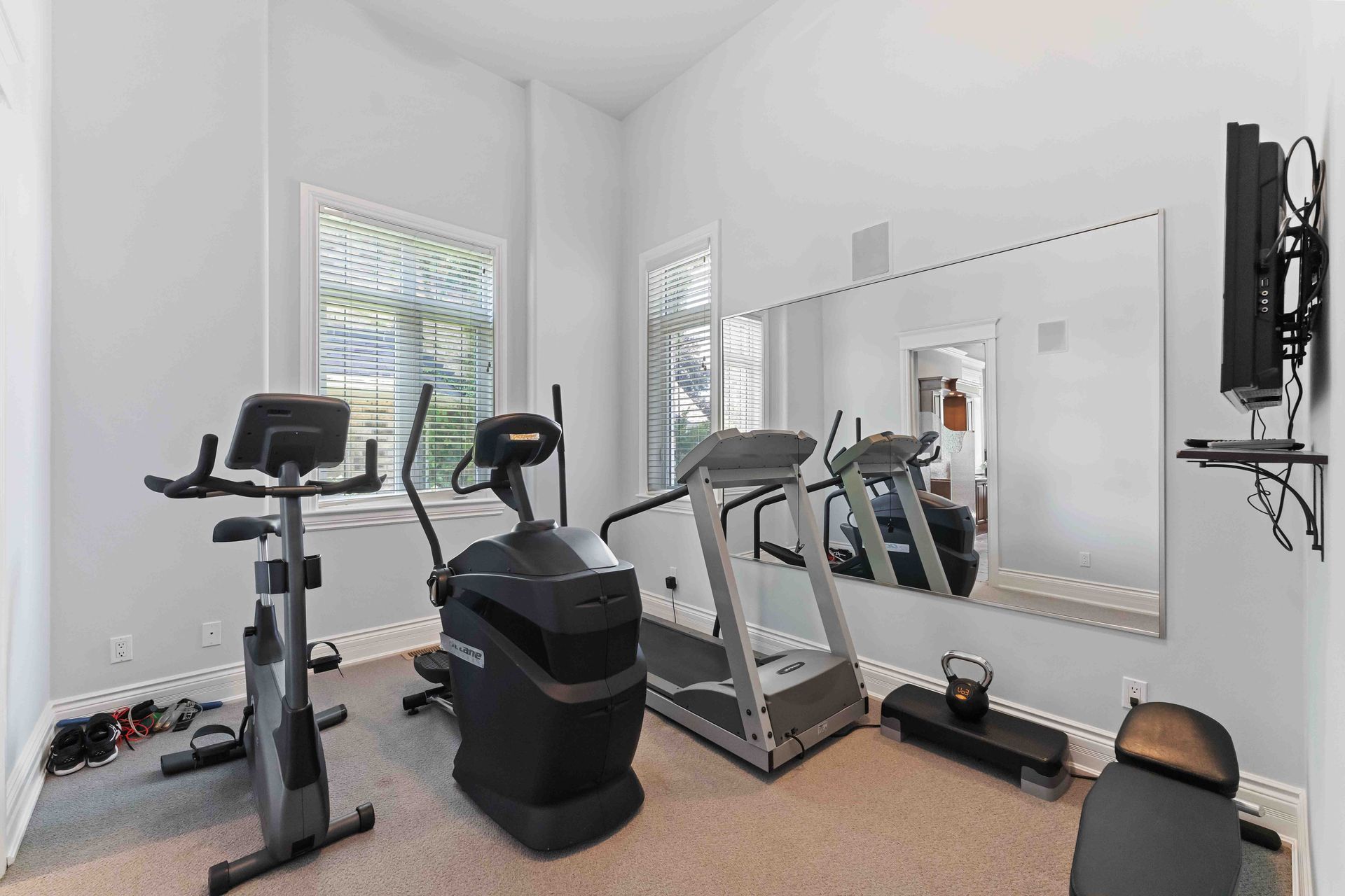 A gym with treadmills , exercise bikes , and a large mirror.