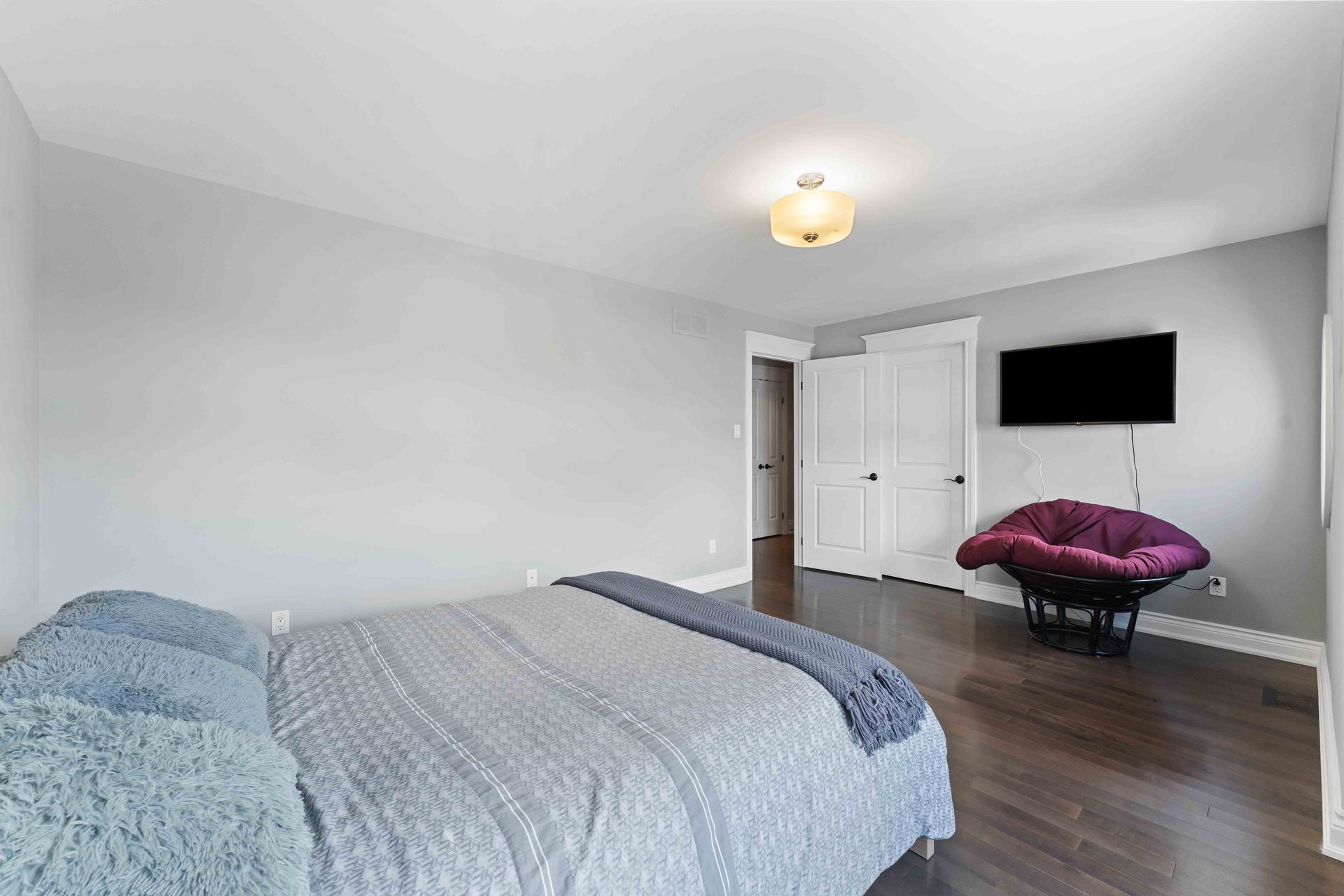 A bedroom with a bed , chair and television.