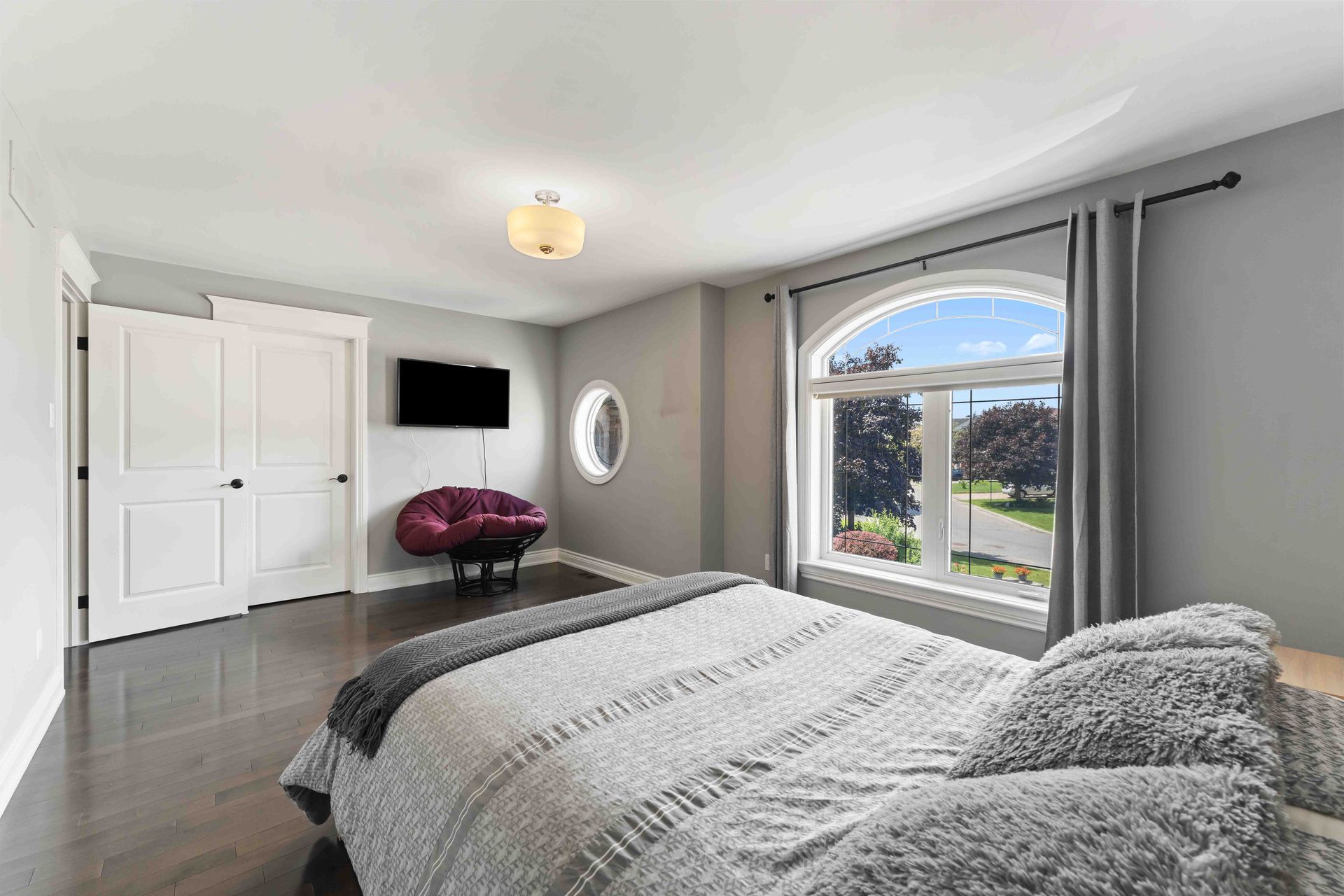 There is a large bed in the middle of the room with a large window.