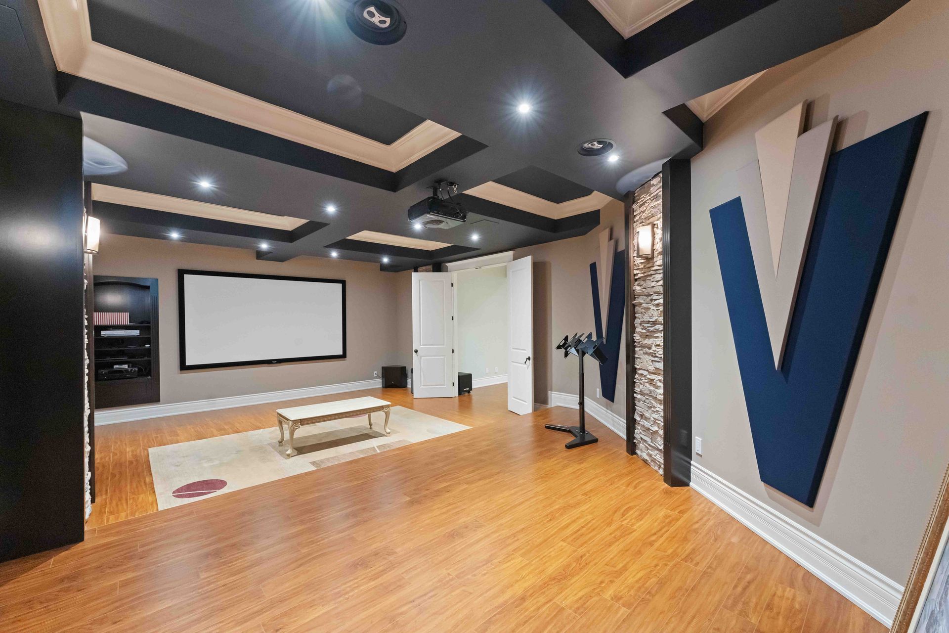 A home theater with a projector and a large v on the wall.