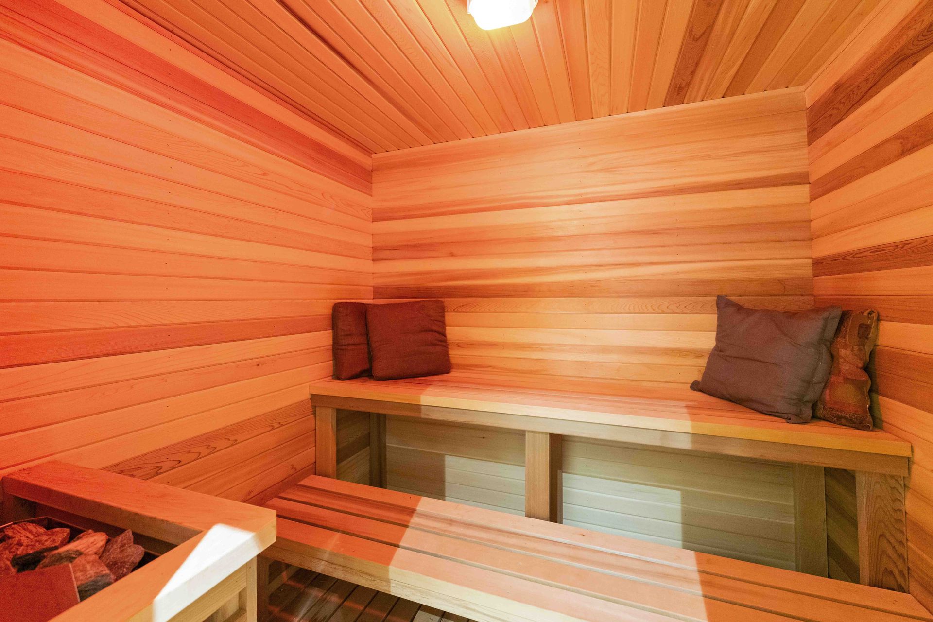 A wooden sauna with wooden benches and pillows.