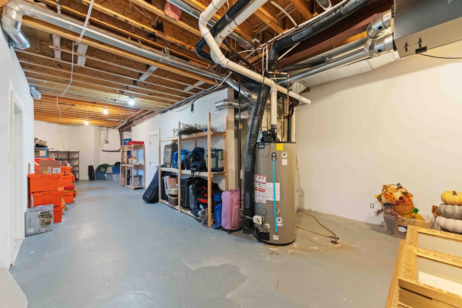 There is a water heater in the basement of a house.