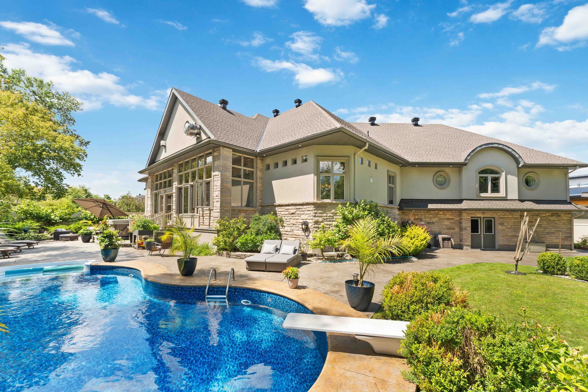 A large house with a large swimming pool in front of it.