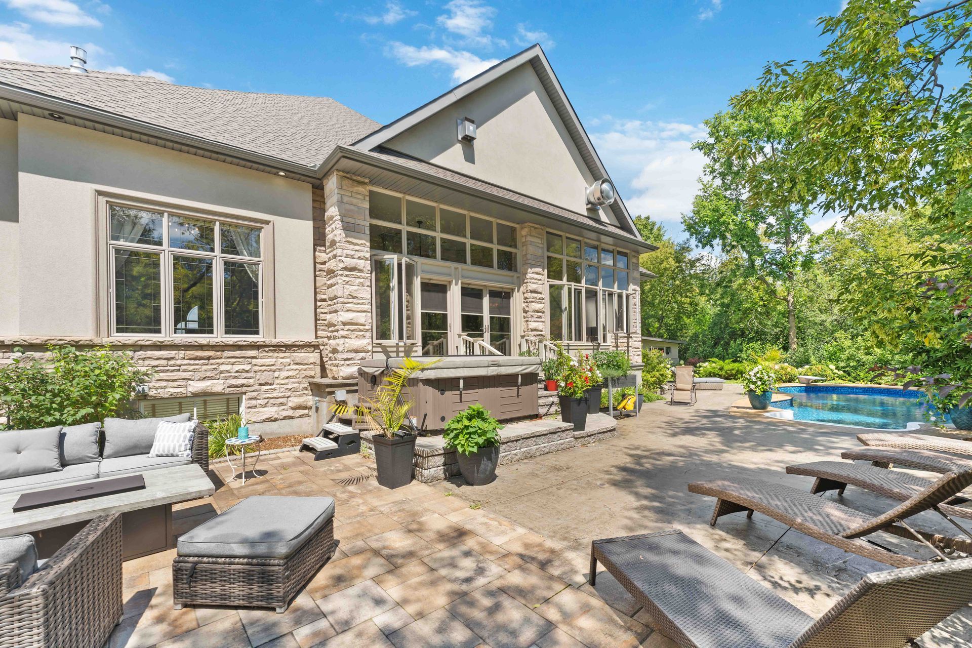 A large house with a patio and a pool in front of it.
