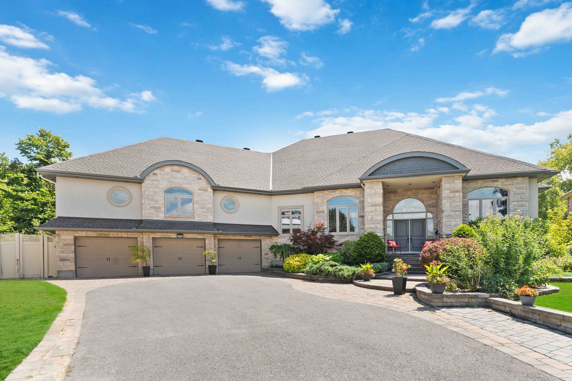 A large house with a lot of windows and a driveway leading to it.