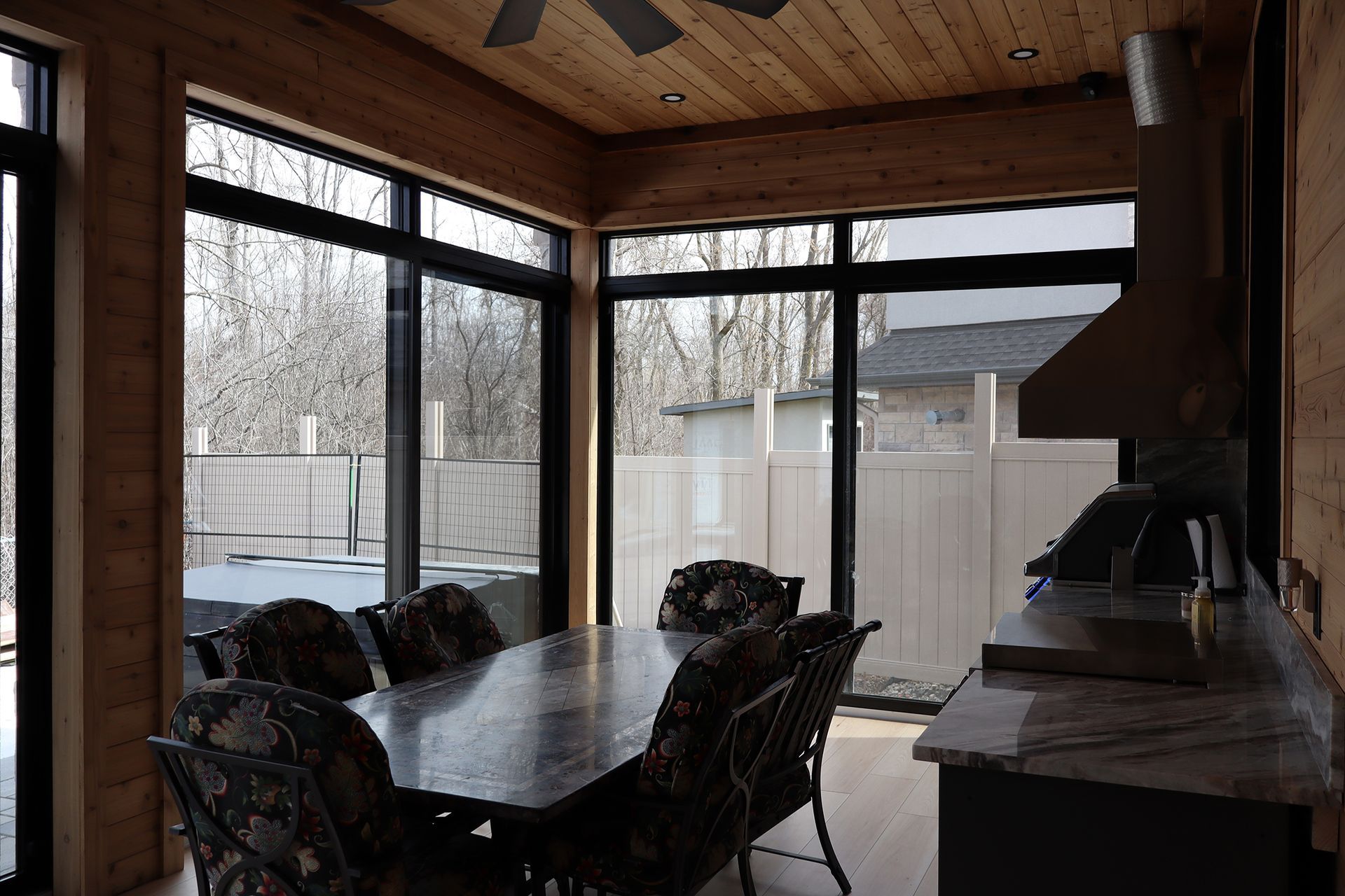 A dining room with a table and chairs and a ceiling fan.