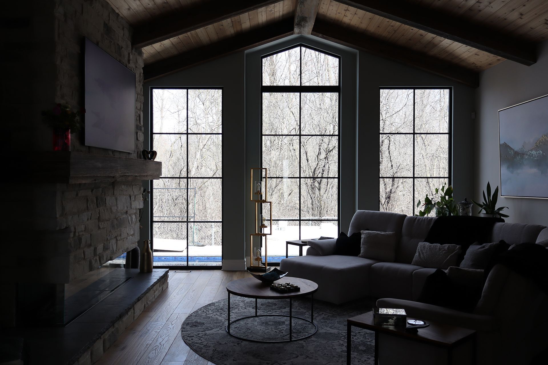 A living room with a couch , fireplace , and large windows.