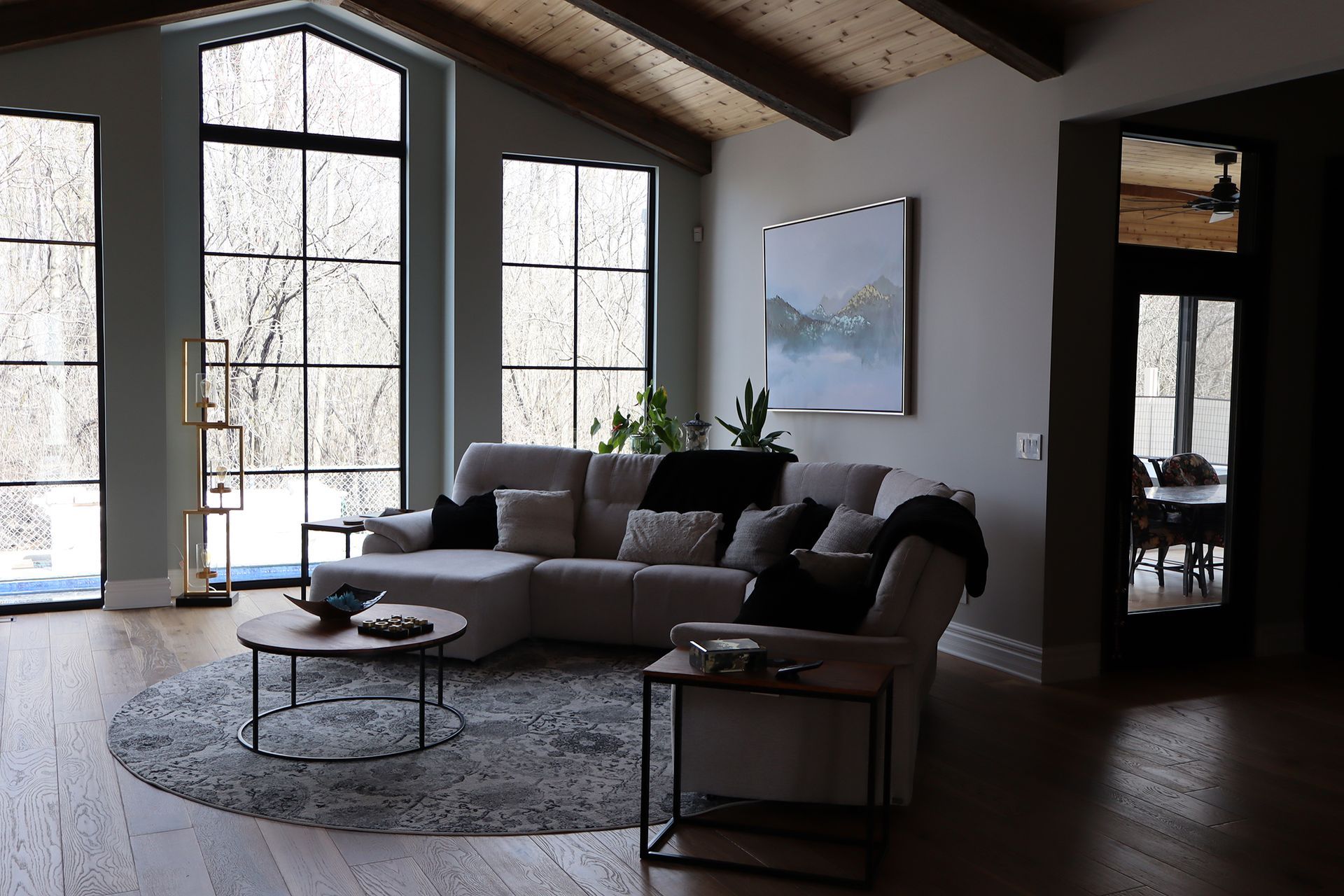 A living room with a couch , chair , coffee table and large windows.