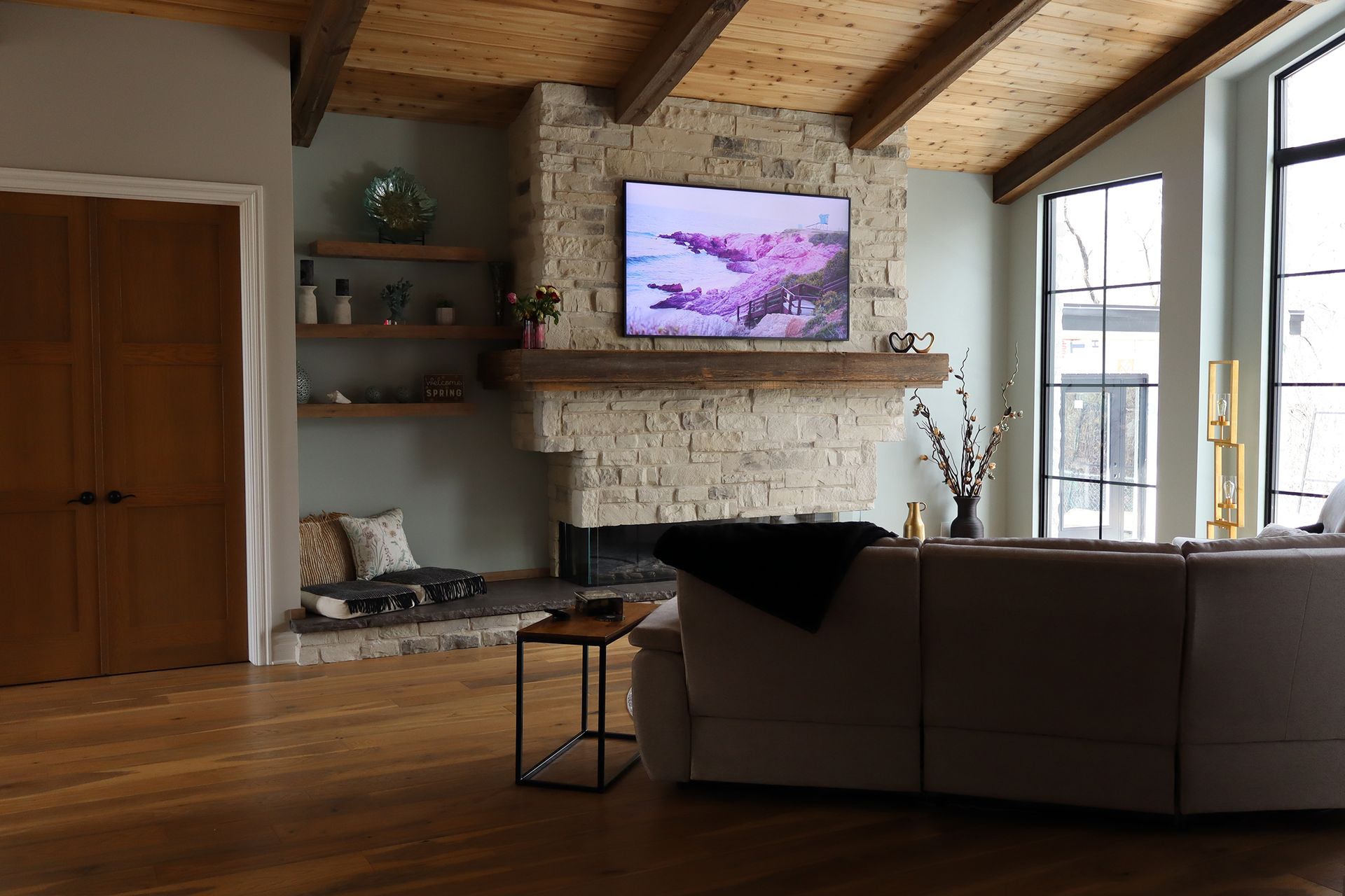A living room with a fireplace and a flat screen tv on the wall.