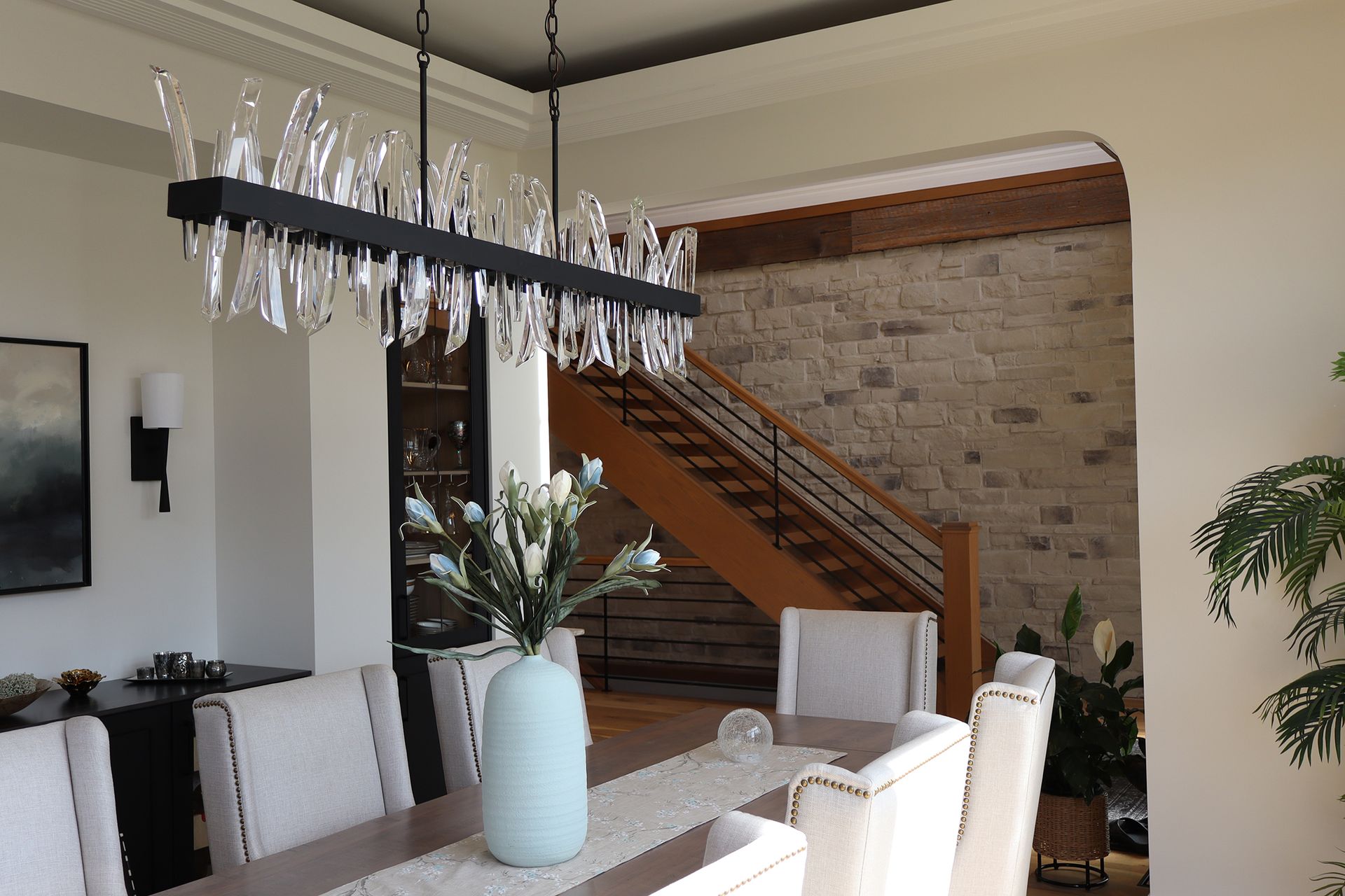 A dining room table with a vase of flowers on it