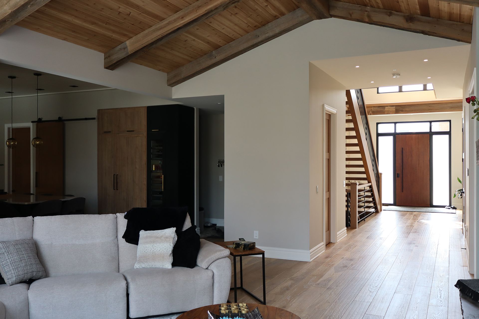 A living room with a white sectional couch and a wooden table