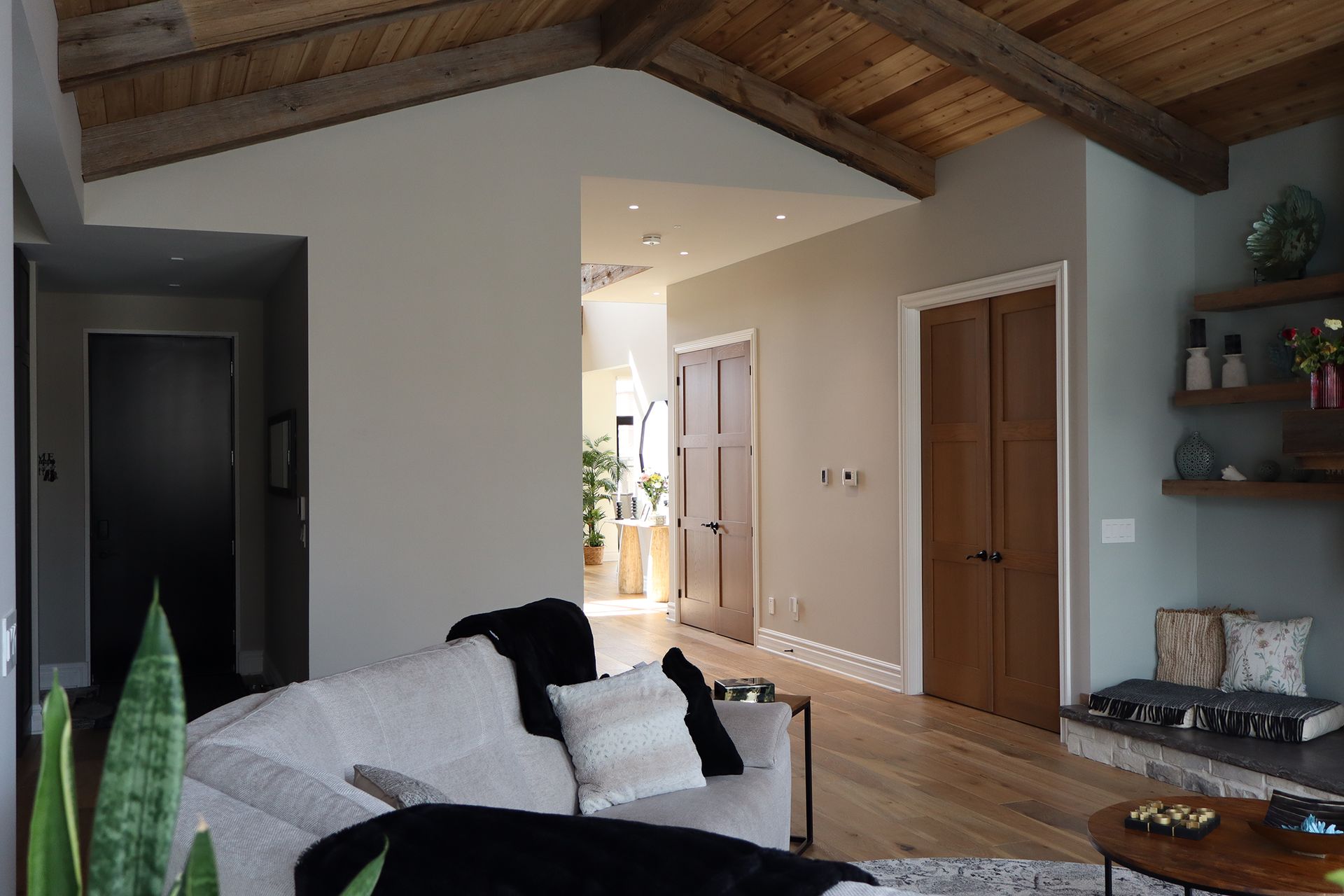 A living room with a couch , table , and a wooden ceiling.