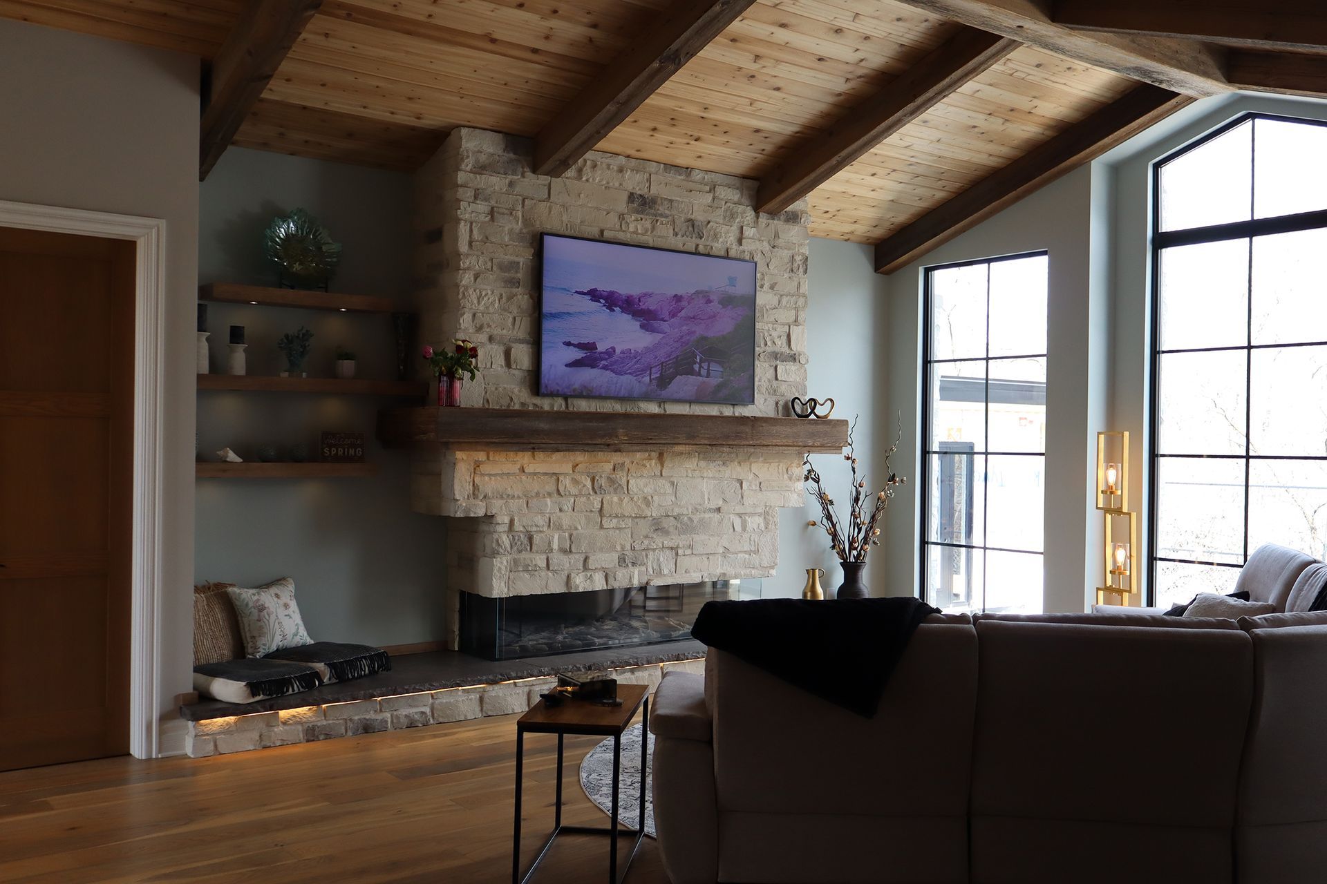 A living room with a fireplace and a flat screen tv on the wall.