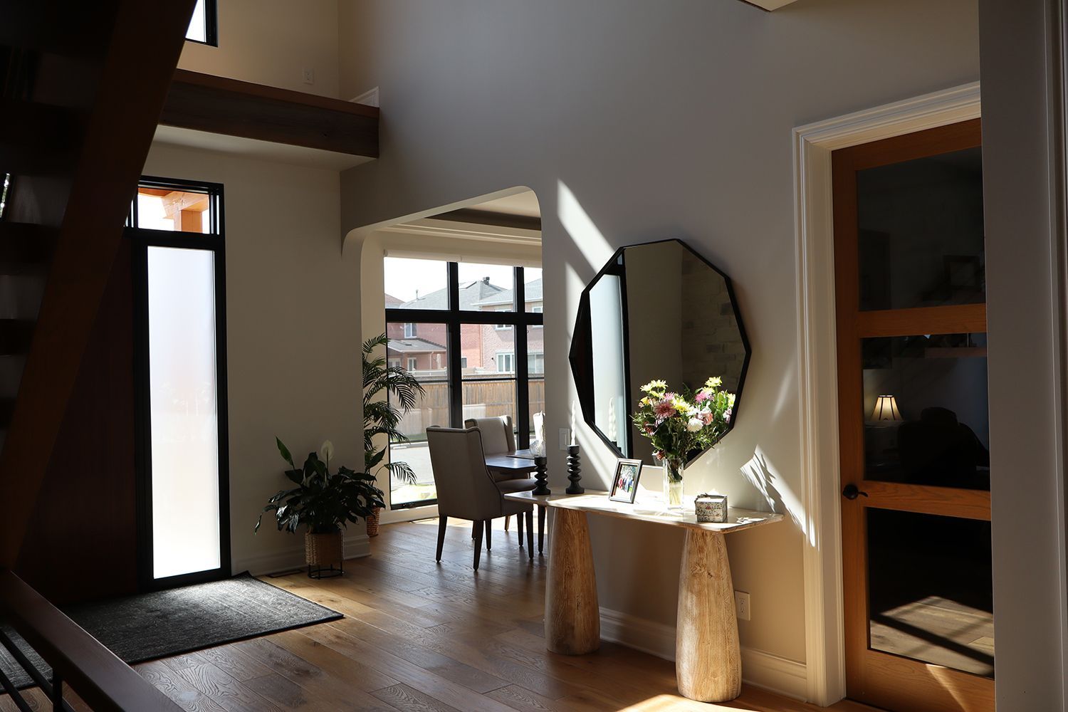 A hallway in a house with a round mirror on the wall.