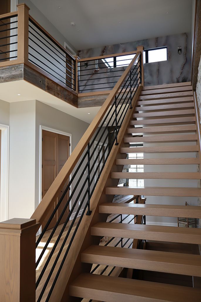 A wooden staircase with a metal railing in a house.