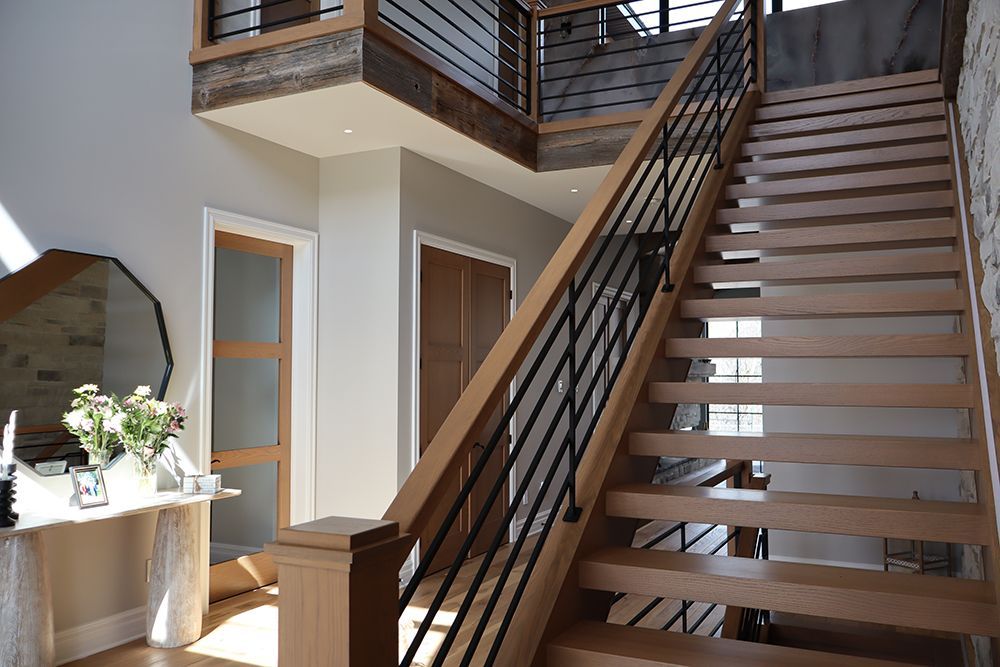 A wooden staircase with a metal railing in a house.