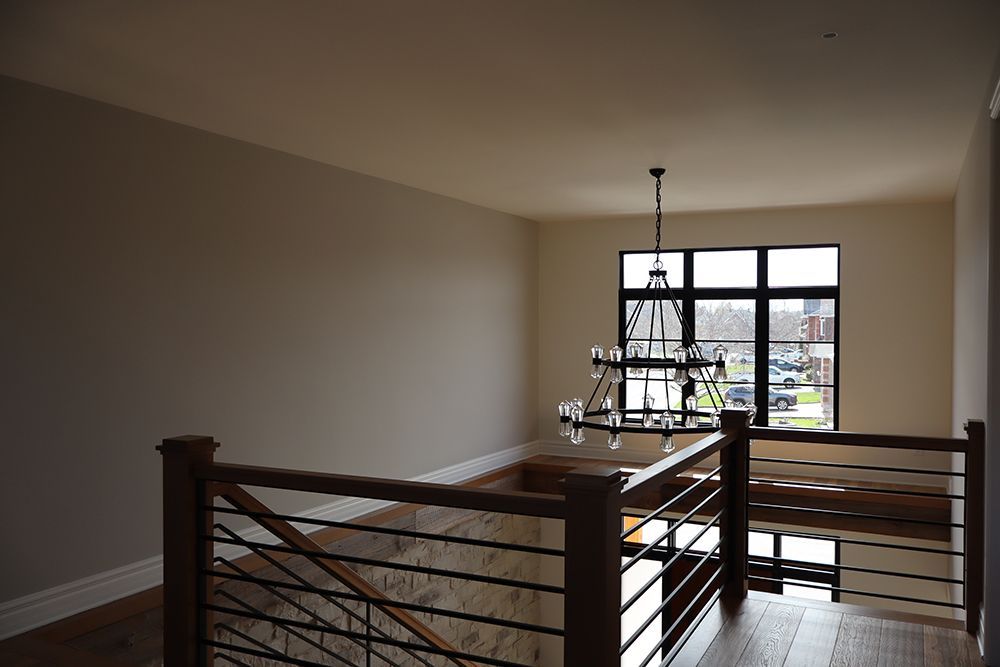 An empty room with a staircase and a window.