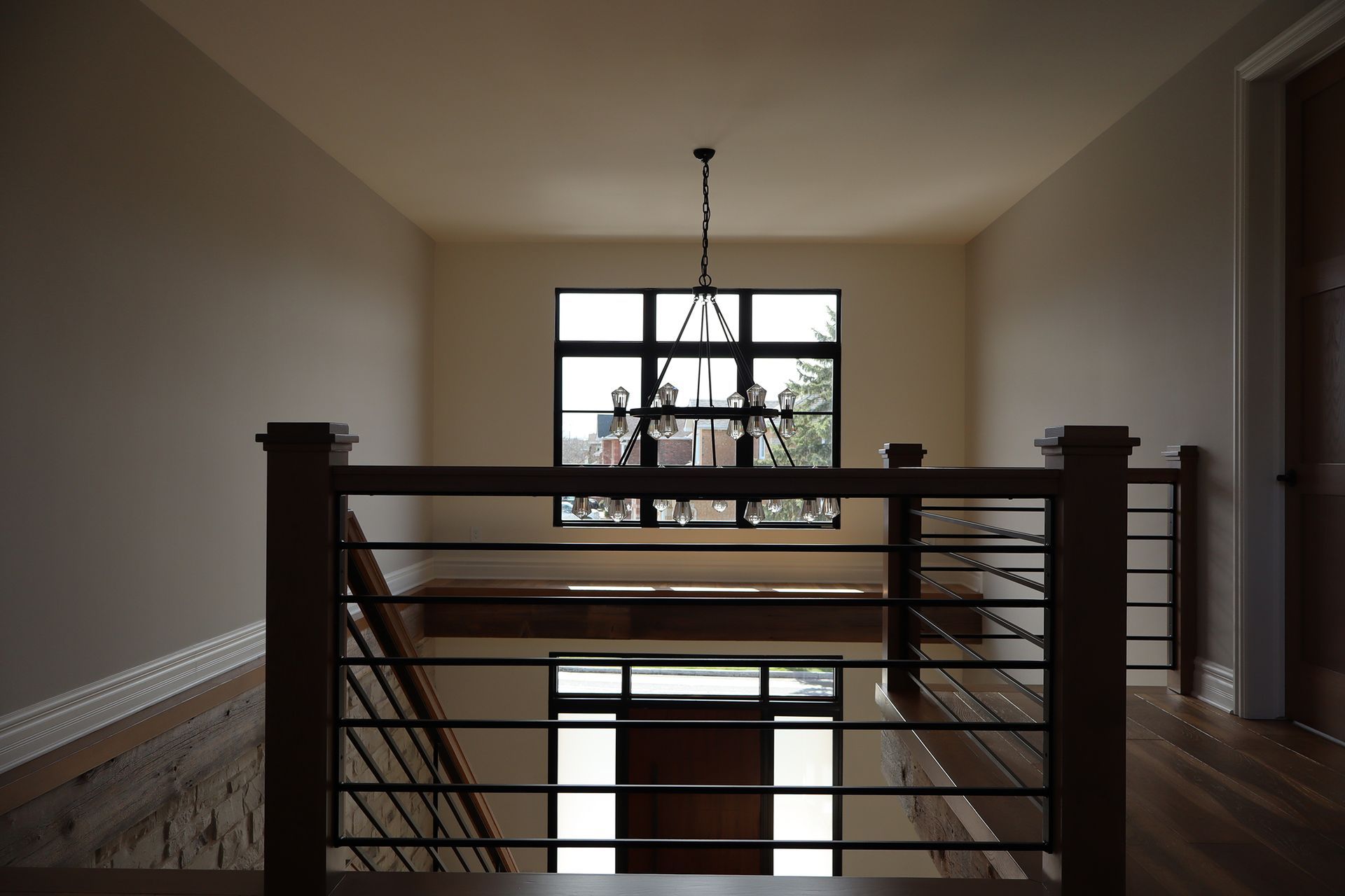 A staircase in a house with a chandelier hanging from the ceiling