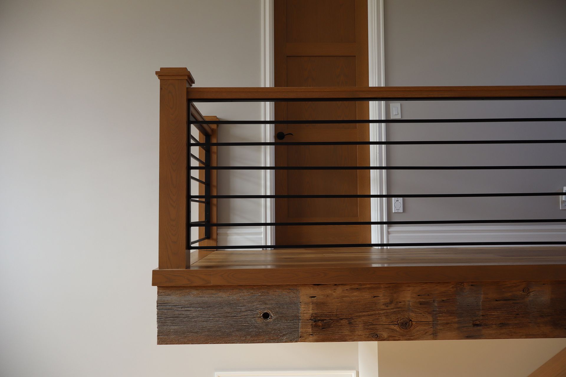 A staircase with a wooden railing and a metal railing