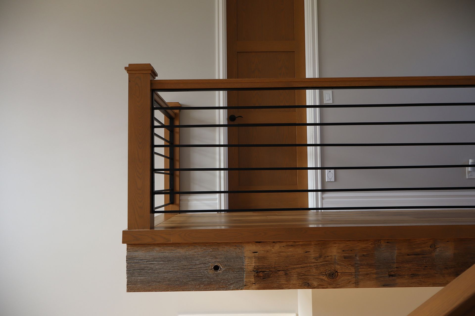 A staircase with a wooden railing and a metal railing