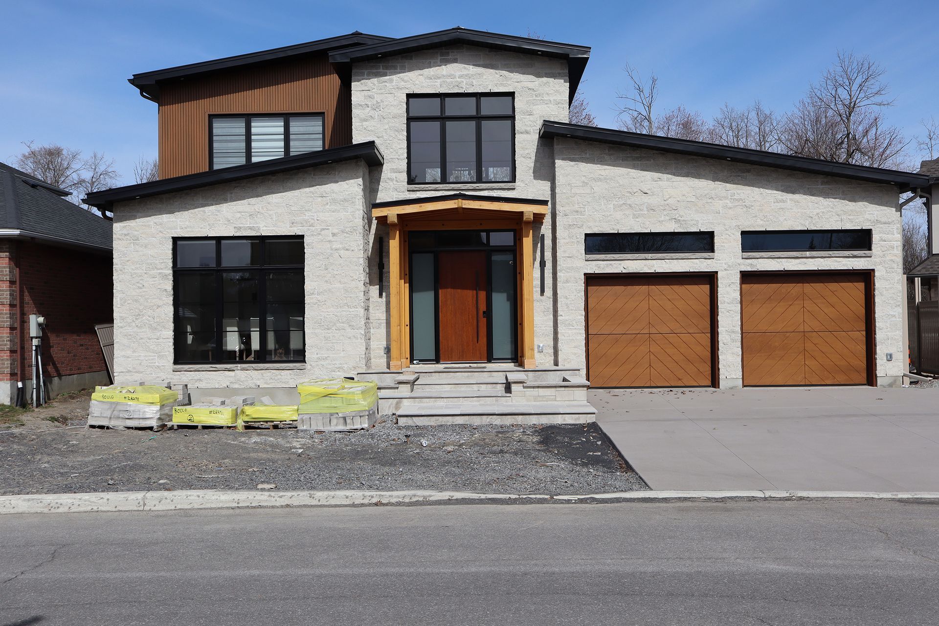 A large white house with two garage doors is being built.