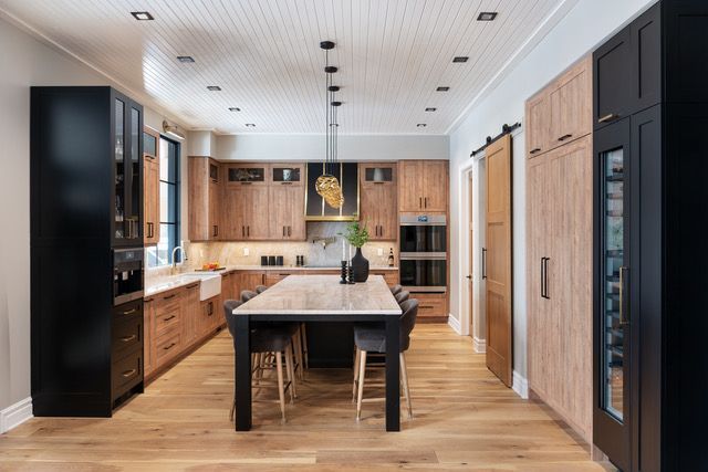 A kitchen with wooden cabinets and a large island in the middle.