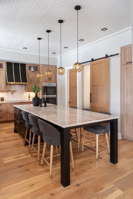 A kitchen with a long table and chairs and sliding barn doors.