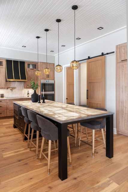 A kitchen with a long dining table and chairs